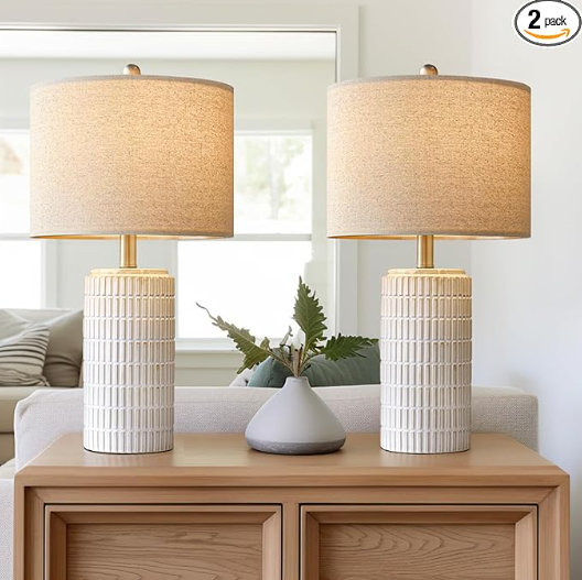 Pair of PoKat 23" modern white ceramic table lamps with beige shades, perfect for a living room.