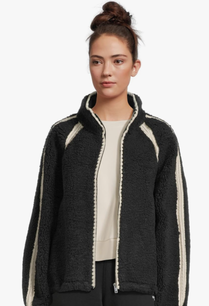 A stylish woman smiling, wearing the soft UGG Nikia Crochet Uggfluff Jacket outdoors.